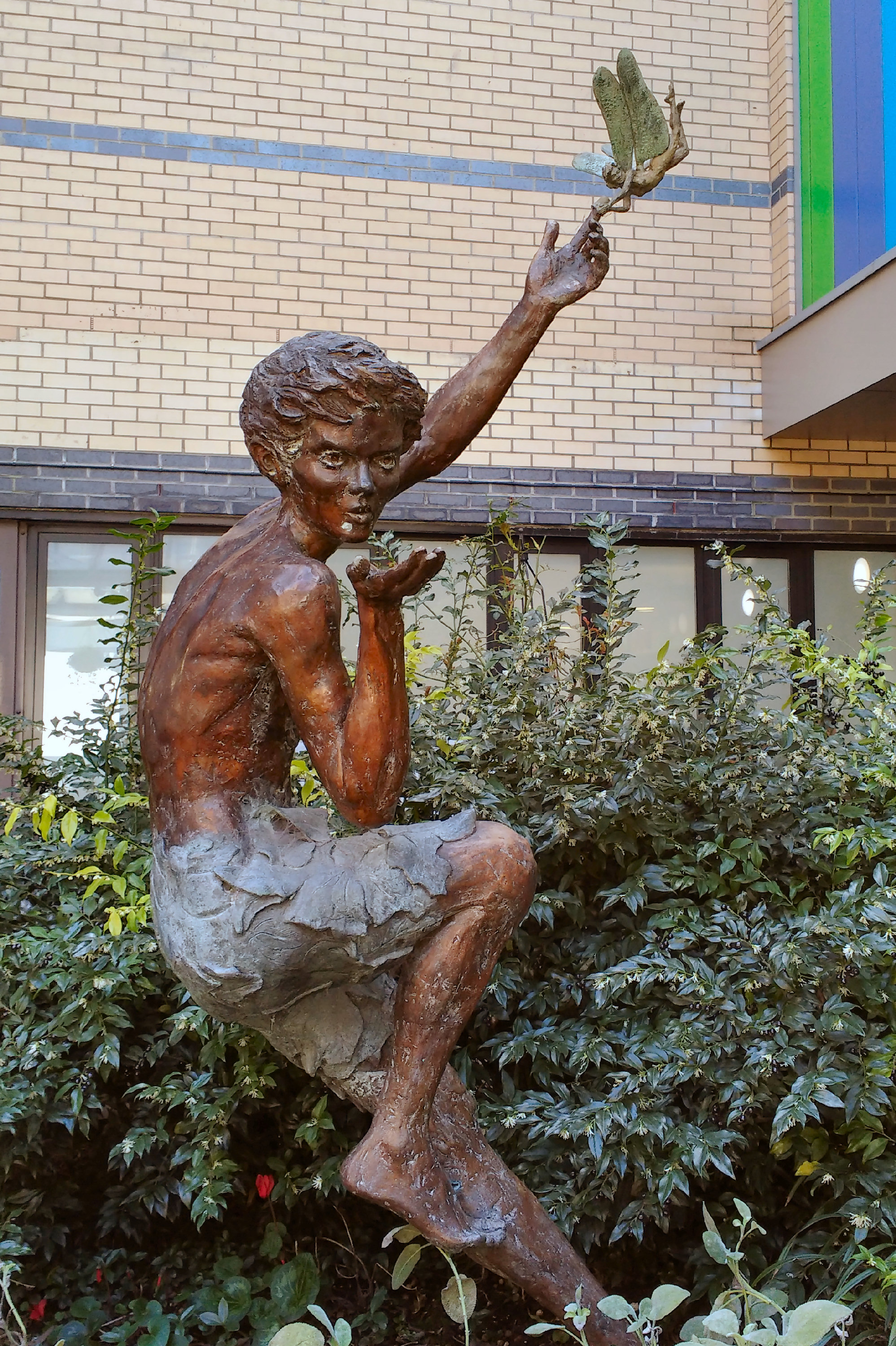 Bronze Peter Pan raises one hand toward Tinker Bell outside Great Ormond Street Hospital in a 2019 photograph.